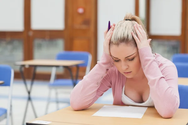 woman-looking-at-exam-paper-in-anxiety